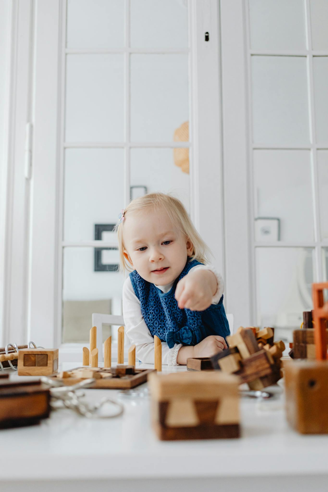 A child playing with wooden educational toys indoors, fostering creativity and learning.