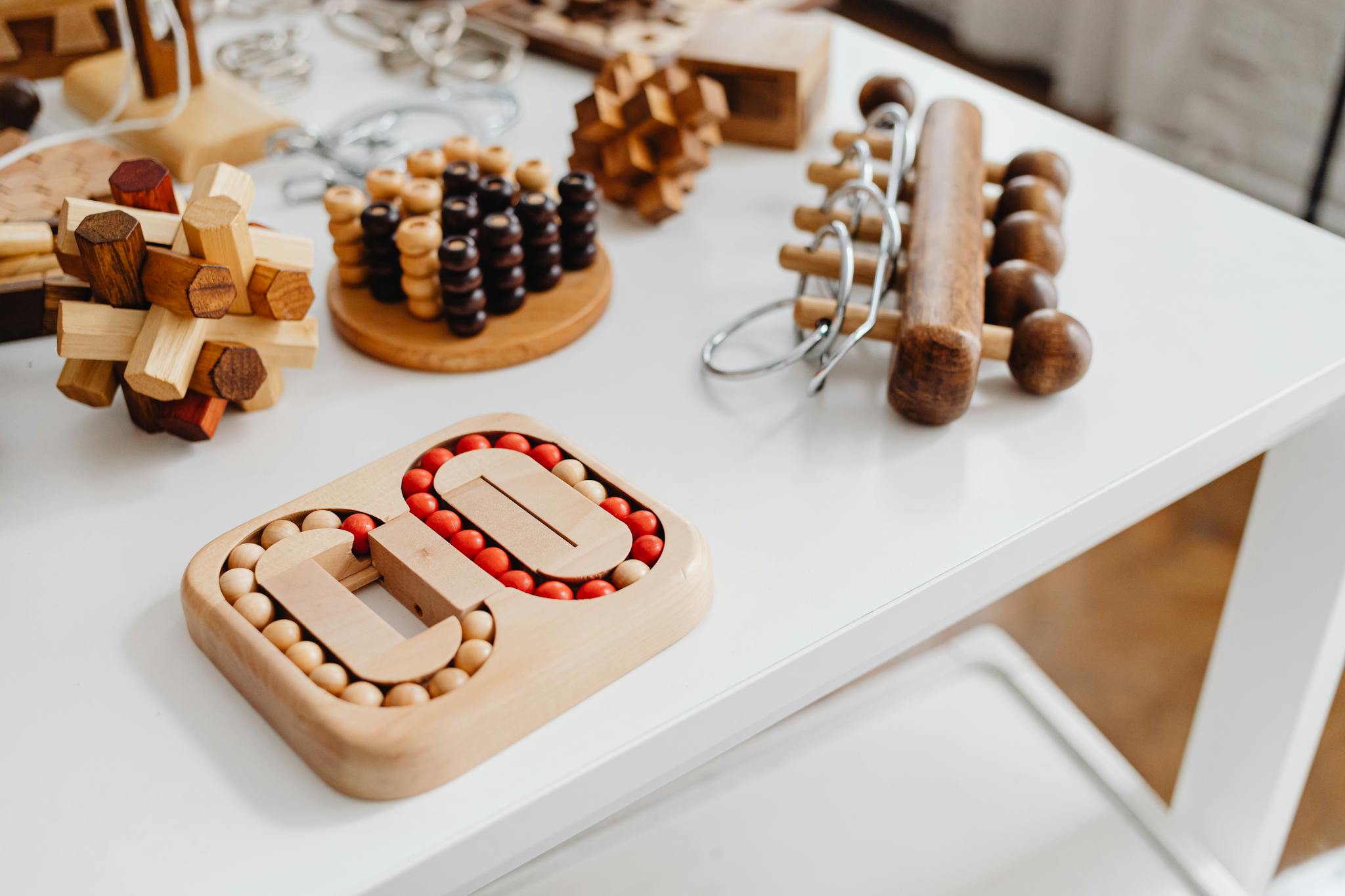 A collection of wooden brain teasers and puzzles on a table, showcasing various designs and structures.