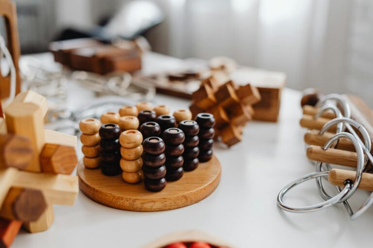 Close-up of various wooden brain teaser puzzles arranged on a table indoors.