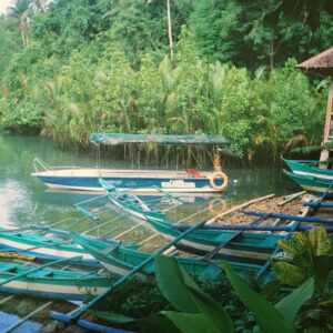Tropical River wooden jigsaw puzzle artwork with boats river reflections and lush green banks